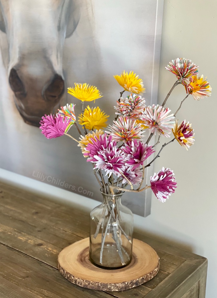 A fun and easy craft idea for adults! These cupcake liner flowers are beautiful displayed on your entry table, dining table, kitchen island or even fireplace mantel. If you're looking for DIY home decor projects to make, this flower bouquet is inexpensive and really charming. So easy to make! You really can't mess it up. Just gather some sticks from your yard and get to gluing!