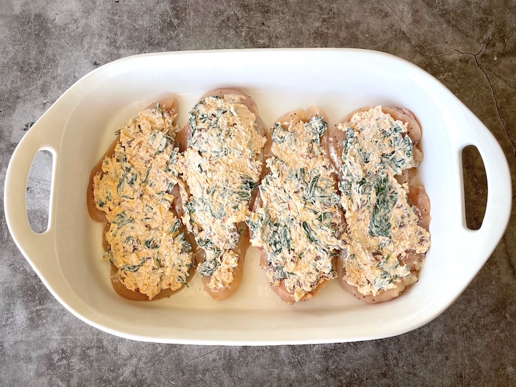 Chicken breasts in a baking dish topped with a yummy cream cheese mixture to make a low carb and easy dinner recipe.