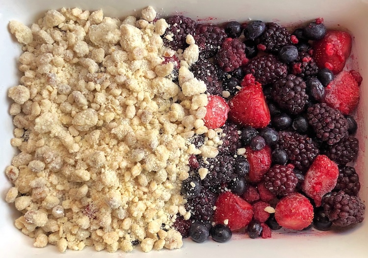 Super easy baked berry cobbler recipe with yellow cake mix, frozen fruit, oats, walnuts, and butter. Easy fruit dessert to serve with vanilla ice cream.