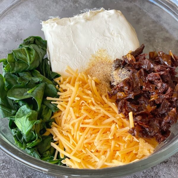 Cream cheese baked chicken with spinach, cheddar, and sun-dried tomatoes.