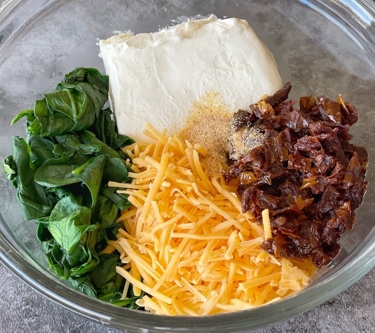 Cream cheese baked chicken with spinach, cheddar, and sun-dried tomatoes.